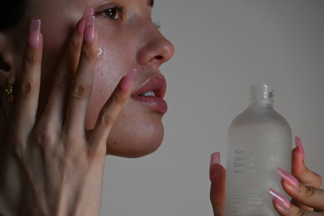 A close-up of a person applying skincare products with a focus on their hands and the products, emphasizing the importance of proper application.