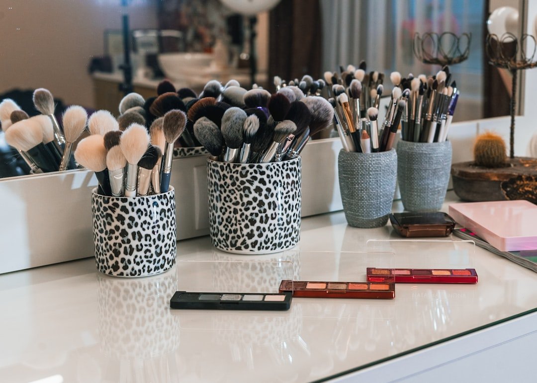 A beautifully arranged luxury makeup collection featuring elegant palettes, brushes, and cosmetics in soft lighting.