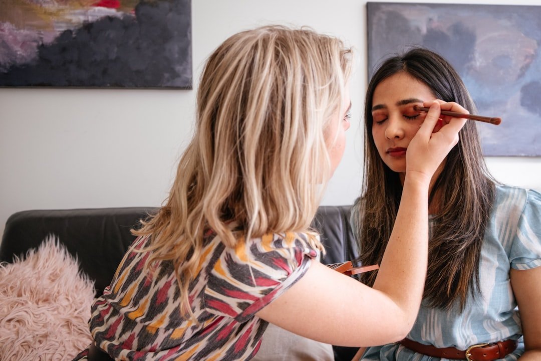 A close-up of a makeup artist applying foundation on a model's face, showcasing different foundation finishes.