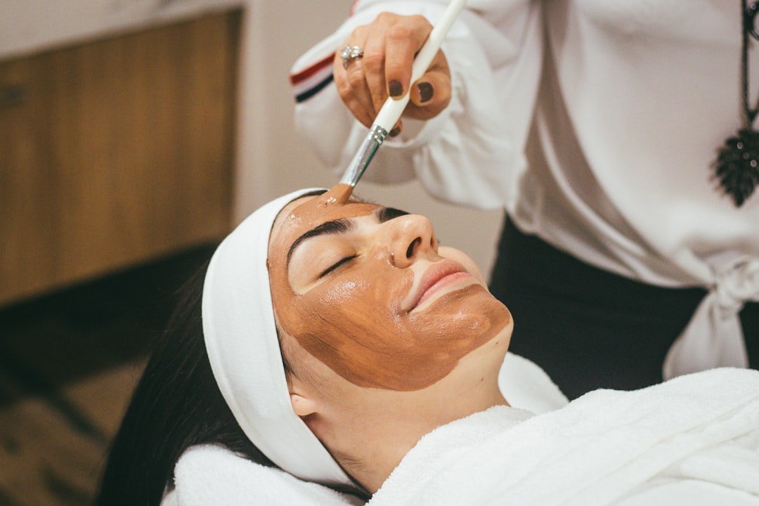 A close-up of a person applying moisturizer to their face, showcasing healthy and glowing skin.