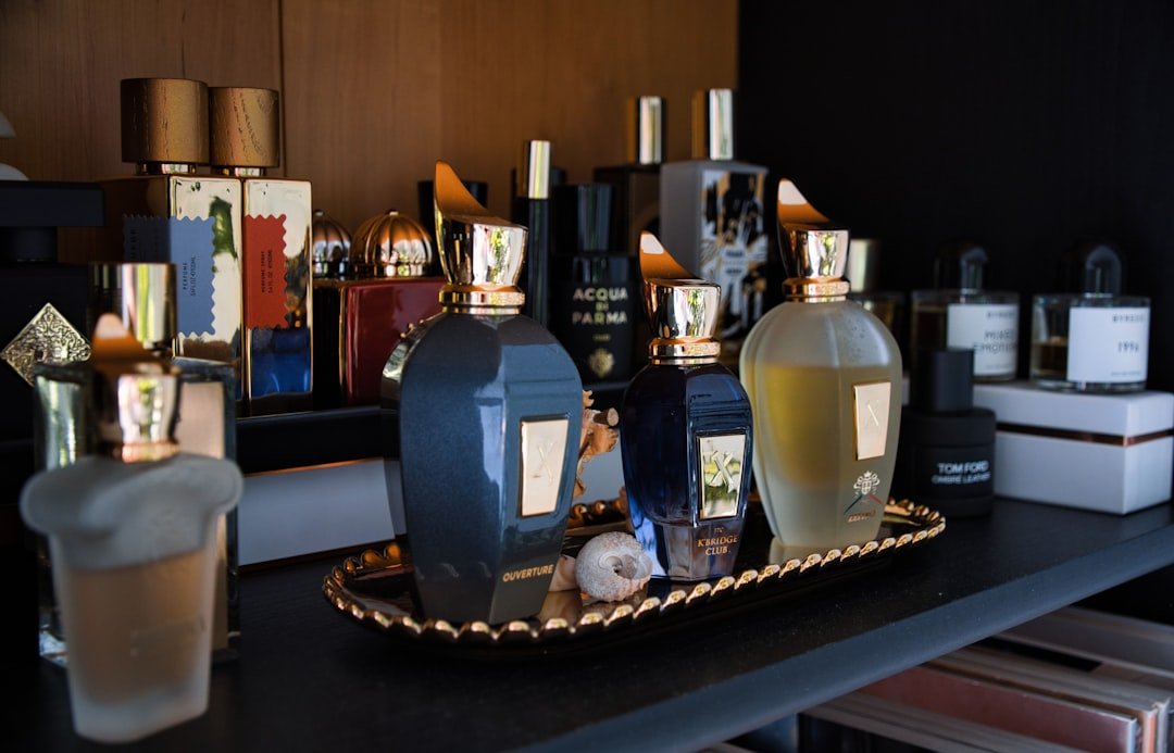 A collection of elegant perfume bottles arranged on a shelf, showcasing various shapes and colors, with soft lighting to highlight their beauty.
