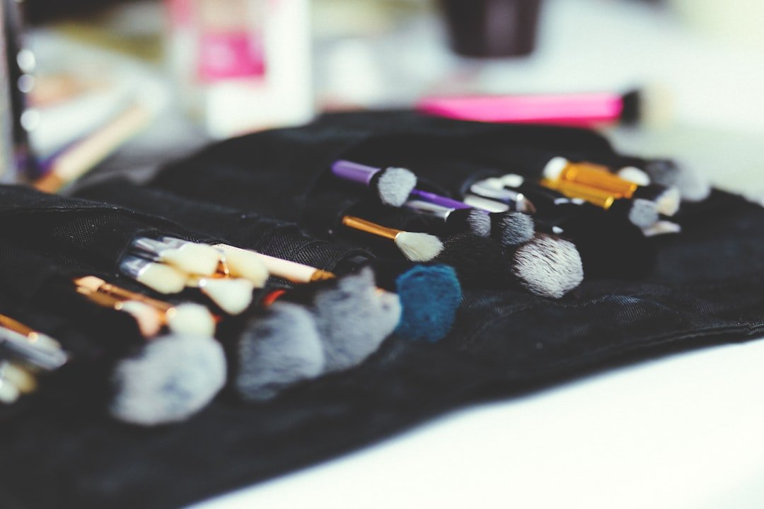 A collection of makeup brushes arranged in a black brush roll, shown in a close-up with shallow focus.